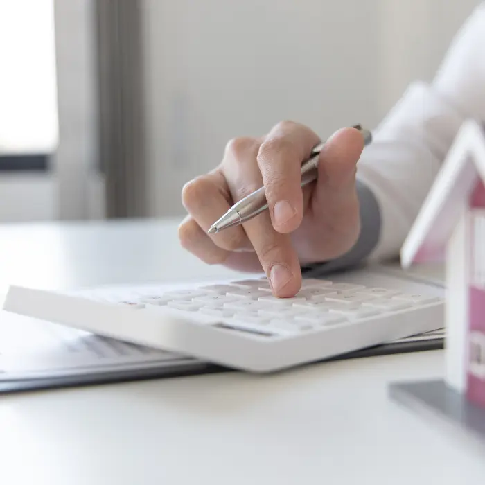 Close up hand calculating property valuation Near Dearborn, MI